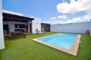 a backyard with a swimming pool and green grass at Casa Horizonte in La Costa