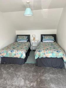 two beds sitting next to each other in a bedroom at El Sea House in Chapel Saint Leonards