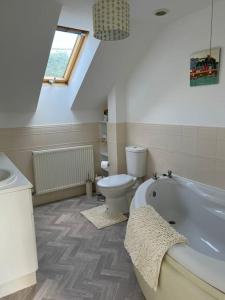 a bathroom with a toilet and a bath tub at El Sea House in Chapel Saint Leonards