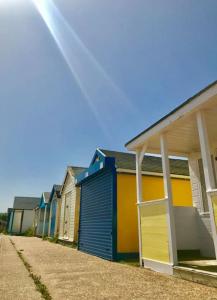 a row of colorful homes on a dirt road at El Sea House in Chapel Saint Leonards