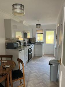 a kitchen with white appliances and a table and chairs at El Sea House in Chapel Saint Leonards +16 photos