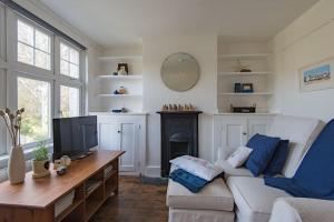 a living room with a couch and a tv at Poppy Cottage in Kingsdown