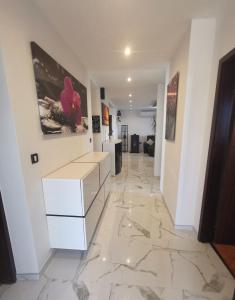 烏馬格的住宿－Apartman Adamović，铺有大理石地板并配有白色梳妆台的走廊