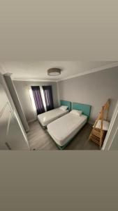 Habitación pequeña con 2 camas y ventana en 2 bedroom flat with swimming pool for rent mazi village of bodrum, en Bodrum City