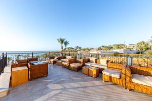 a deck with couches and chairs on the beach at The Grand Hotel Sharm El Sheikh in Sharm El Sheikh