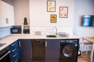 a kitchen with a washing machine and a sink at Blackpool Abode - Beach Suite Apartment in Blackpool