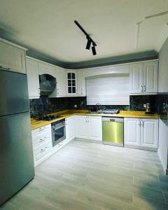 cocina con armarios blancos y ventilador de techo en 2 bedroom flat with swimming pool for rent mazi village of bodrum, en Bodrum City