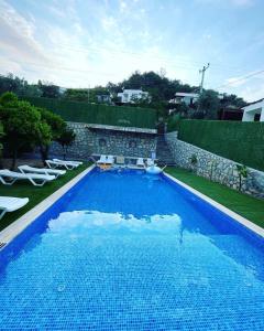 una gran piscina azul en un patio en 2 bedroom flat with swimming pool for rent mazi village of bodrum, en Bodrum City