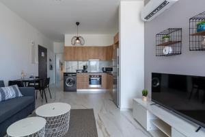 a living room and kitchen with a couch and a table at Yasou 1- Bedroom Apartment in Larnaca in Larnaca