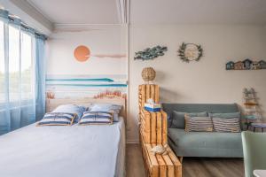 un dormitorio con una cama y un sofá en L'Escale de la Plage, en Gruissan