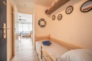 Habitación con cama y relojes en la pared en L'Escale de la Plage, en Gruissan
