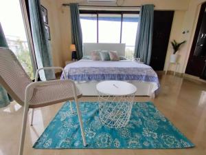 1 dormitorio con 1 cama, 1 silla y 1 alfombra en 7 - Studio Velankanni Heights, Behaind Nanavati Hospital, Vile Parle by Connekt Homes en Bombay