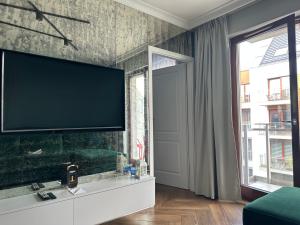 a living room with a large flat screen tv on a wall at Maya's Flats & Resorts 34 - Chmielna 73 in Gdańsk