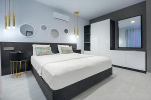 1 dormitorio con 1 cama blanca grande y espejo en Bayram Apart Hotel, en Alanya