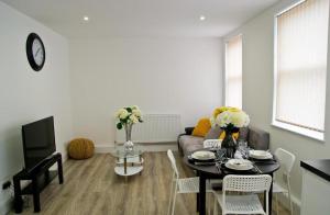 uma sala de estar com uma mesa e um sofá em Lovely 2-bedroom apartment in the heart of chelmsford em Chelmsford