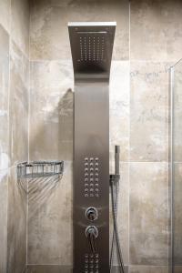 a shower with a shower head in a bathroom at Kyma Rooms & Suites in Kardamaina