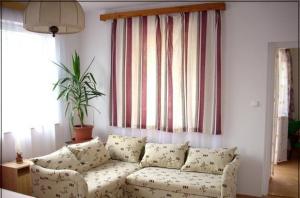 a living room with a white couch and a window at Abádi Karmazsin ház in Abádszalók