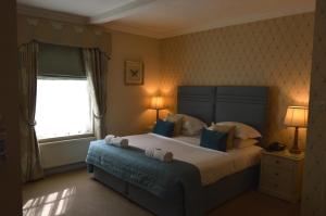 - une chambre avec un grand lit et une fenêtre dans l'établissement Le Bouchon Brasserie & Hotel, à Maldon