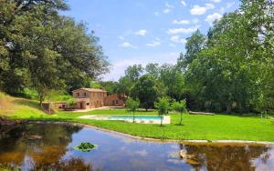 a house with a swimming pool next to a river at Recientemente restaurada, ideal para familias! in Cabanellas
