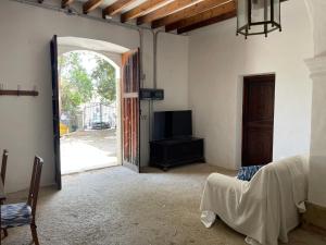 Sala de estar con puerta abierta y TV en Tramuntana home with swimming pool, Can Canonge, en Selva