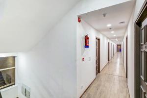 a corridor of a hospital with white walls and wooden floors at Super Townhouse 070 Knowledge Park ||| Near Sharda University in Greater Noida