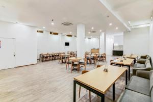 a restaurant with tables and chairs in a room at Super Townhouse 070 Knowledge Park ||| Near Sharda University in Greater Noida