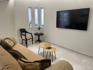 a living room with a couch and a flat screen tv at Eclectic Apartment near Downtown in Heraklio +32 photos