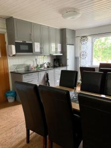 a kitchen with a dining room table and chairs at Stenungsögården in Stenungsund