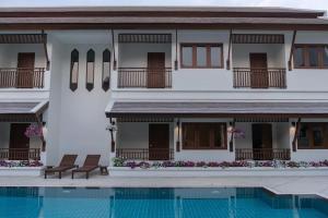 - un bâtiment avec une piscine en face dans l'établissement Villa Sanpakoi, à Chiang Mai