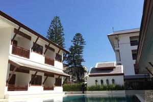 een gebouw met een zwembad naast een gebouw bij Villa Sanpakoi in Chiang Mai