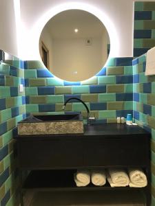 ピナールルにあるHôtel du Golfe Pinarelloのバスルーム(洗面台、鏡付)