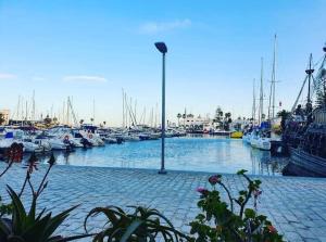a marina with boats and a light pole in the water at Kantaoui appartement haut de gamme in Hammam Sousse