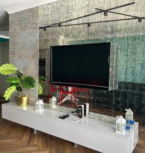 a flat screen tv on a wall in a living room at Maya's Flats & Resorts 34 - Chmielna 73 in Gdańsk