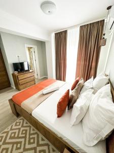 a bedroom with a large bed with pillows at House Lake in Techirghiol