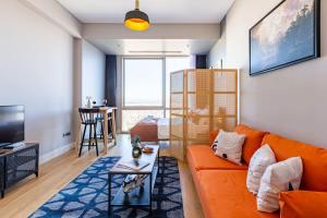 a living room with an orange couch and a table at Studio Flat with Panoramic City View in Atasehir in Istanbul