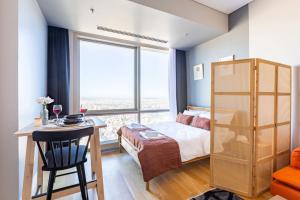 a bedroom with a bed and a desk and a large window at Studio Flat with Panoramic City View in Atasehir in Istanbul