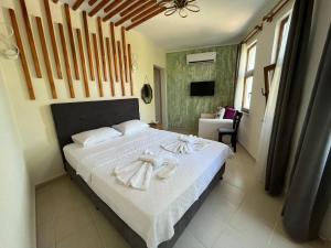 um quarto com uma cama com toalhas em Akar Butik Otel em Gokceada Town