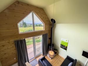 an attic room with a large window and chairs at Tarset Tor - Bothy Cabin 4 in Hexham