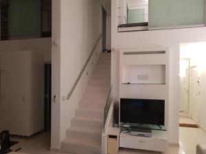 a living room with a staircase with a flat screen tv at Apartments Fontana Zambratija in Zambratija