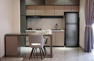 a kitchen with a table and a chair in it at Lun Hotel Manado in Manado