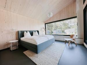 a bedroom with a bed and a large window at Haus 1 - ELF AM SEE in Templin