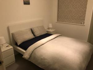a bedroom with a bed with two night stands and two lamps at Private Room & Private Bathroom in Park Royal in London