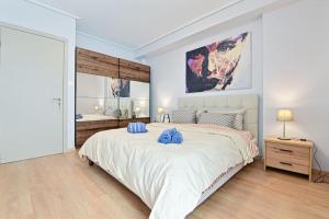 Cozy apartment located on Piraeus Port area-(SPETS_D1) في بيرايوس: غرفة نوم بسرير كبير عليها وسائد زرقاء