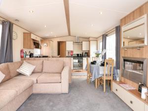 ein Wohnzimmer und eine Küche mit einem Sofa und einem Tisch in der Unterkunft 50, Foxburrow Hang in Great Yarmouth