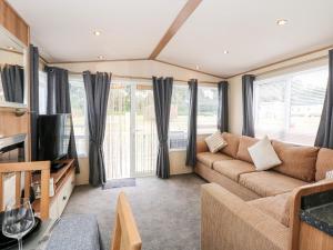 ein Wohnzimmer mit einem Sofa und einem TV in der Unterkunft 50, Foxburrow Hang in Great Yarmouth