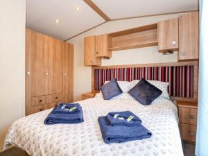 ein Schlafzimmer mit einem Bett mit blauen Handtüchern darauf in der Unterkunft 50, Foxburrow Hang in Great Yarmouth