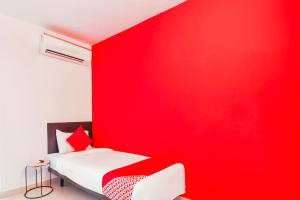 a red bedroom with a white bed and a red wall at Flagship Hotel Maruthi Gandhi Park in Coimbatore