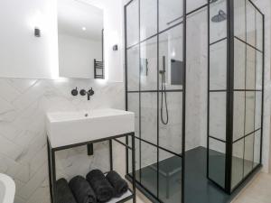 a white bathroom with a sink and a shower at Basswood Barn in Wincanton