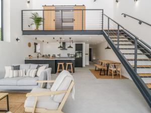 a living room with a staircase and a dining room and kitchen at Tilia Barn in Wincanton