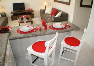 a kitchen with a table with red plates and chairs at Villa Amina in Puerto del Carmen